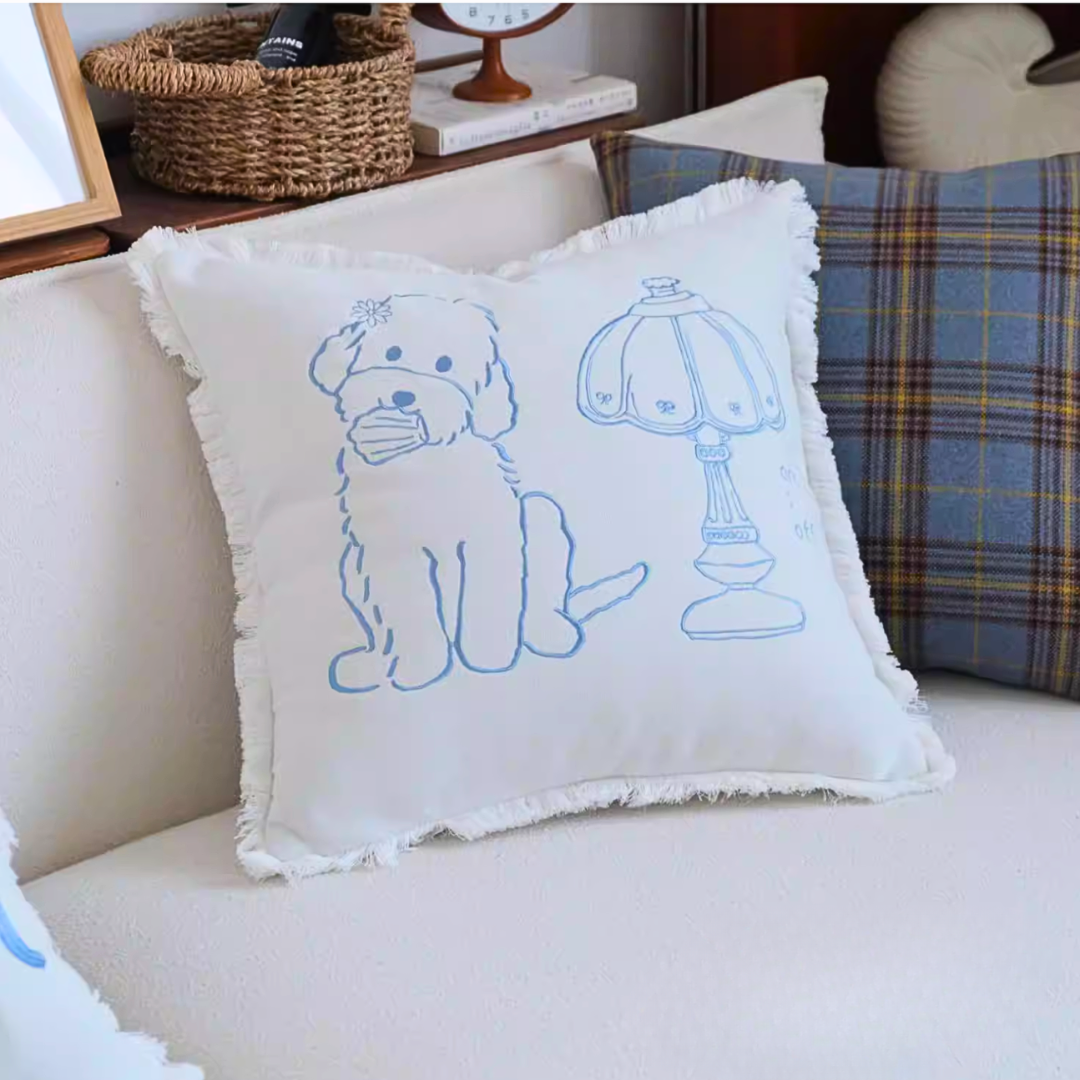 Decorative pillow with a dog and lamp illustration on a couch